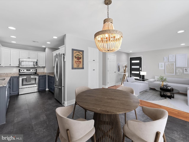 dining area with sink and a notable chandelier