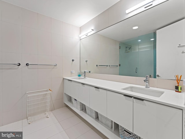 bathroom featuring tile patterned floors, vanity, tile walls, and walk in shower