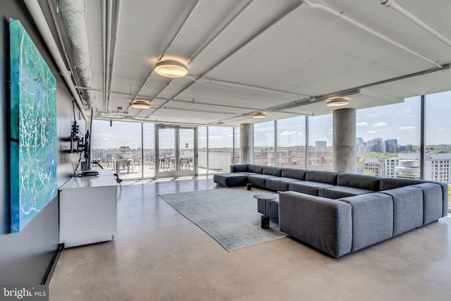 living room with a wall of windows and concrete floors