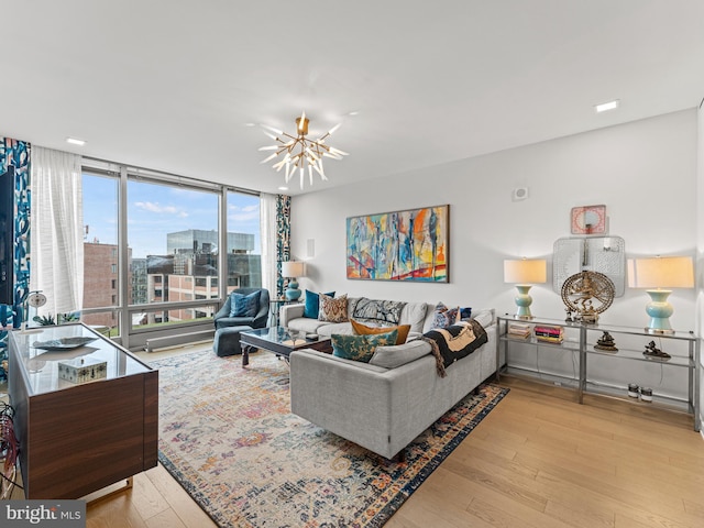 living room featuring a notable chandelier, expansive windows, and light hardwood / wood-style floors