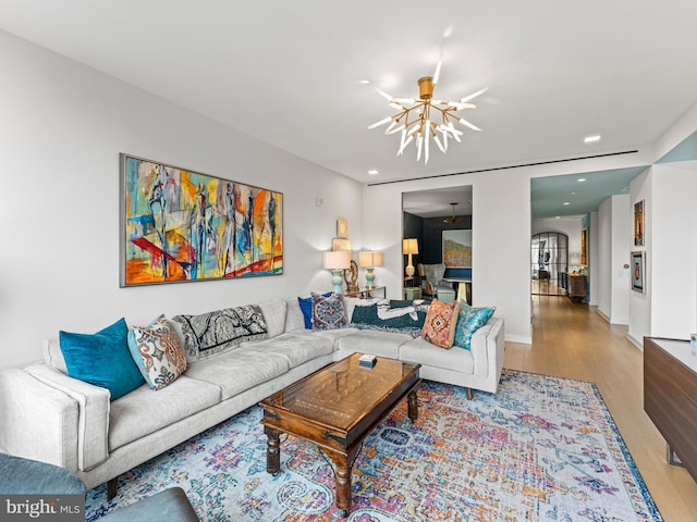 living room with light hardwood / wood-style floors and an inviting chandelier