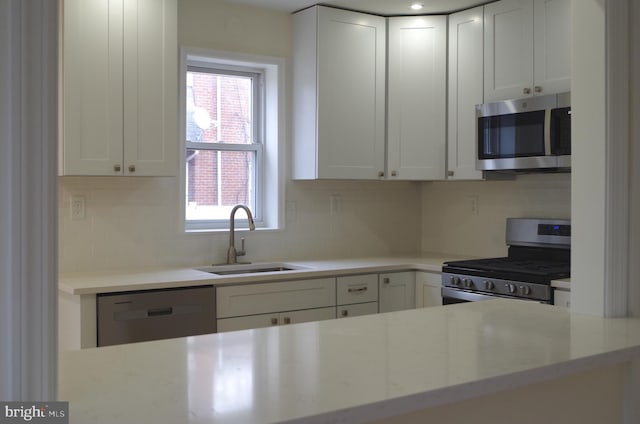 kitchen with white cabinetry, sink, tasteful backsplash, and stainless steel appliances