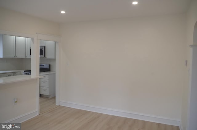 kitchen featuring stainless steel appliances, white cabinets, and light wood-type flooring