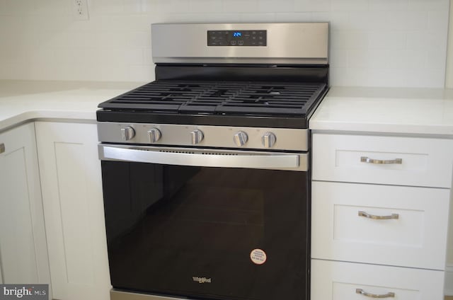 kitchen featuring white cabinetry, gas range, and tasteful backsplash