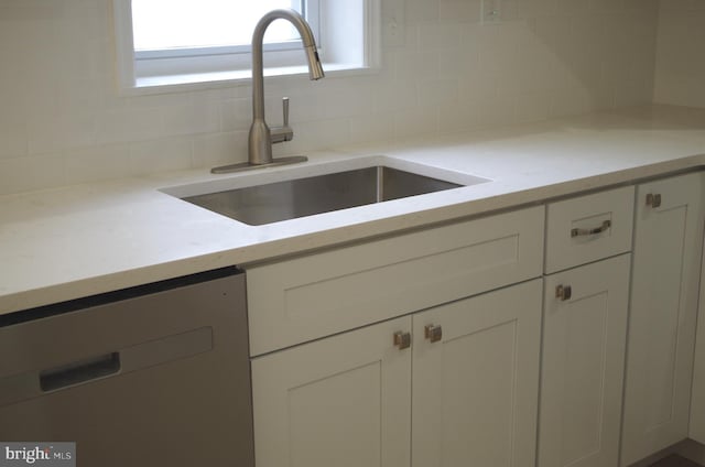 kitchen with sink, backsplash, and white cabinets