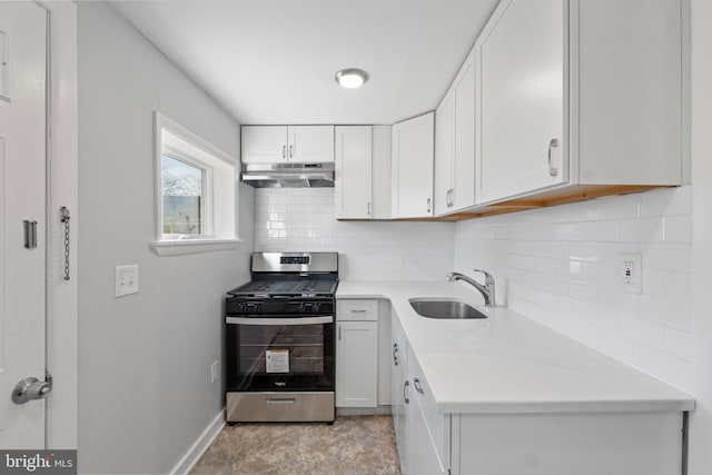 kitchen with decorative backsplash, white cabinetry, sink, and stainless steel gas range