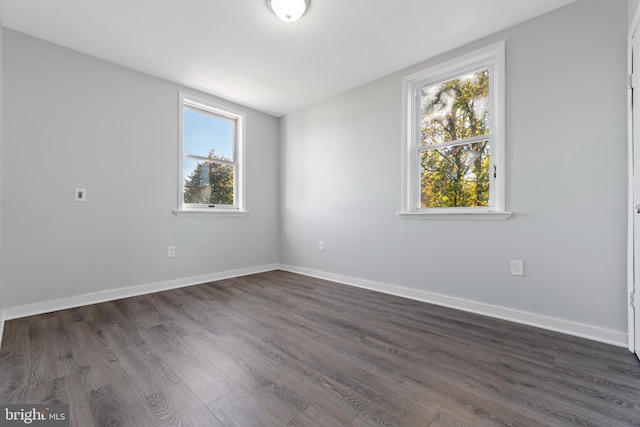 unfurnished room with plenty of natural light and dark wood-type flooring