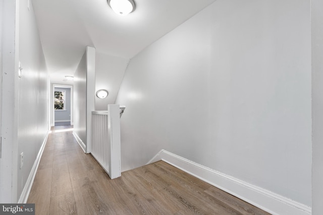 hallway featuring lofted ceiling and light hardwood / wood-style flooring