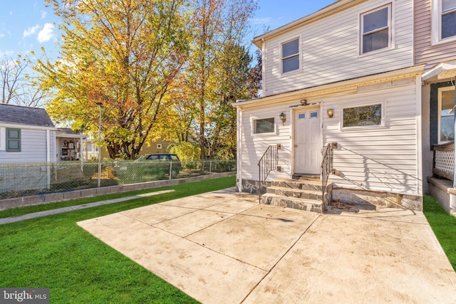 back of house with a patio area and a yard