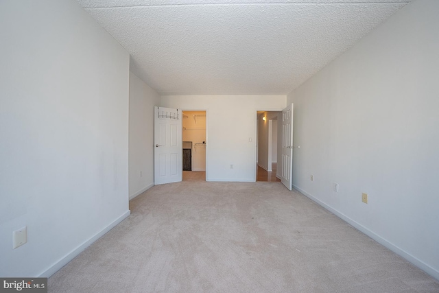 unfurnished bedroom with a textured ceiling and light colored carpet