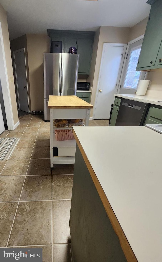 kitchen featuring stainless steel appliances and dark tile patterned floors