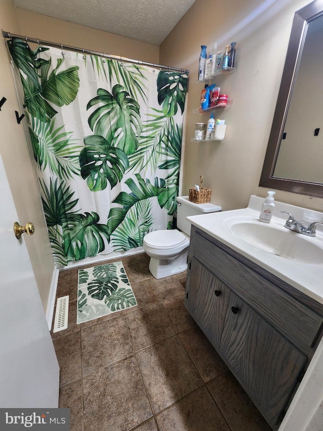 bathroom featuring toilet, vanity, and a textured ceiling