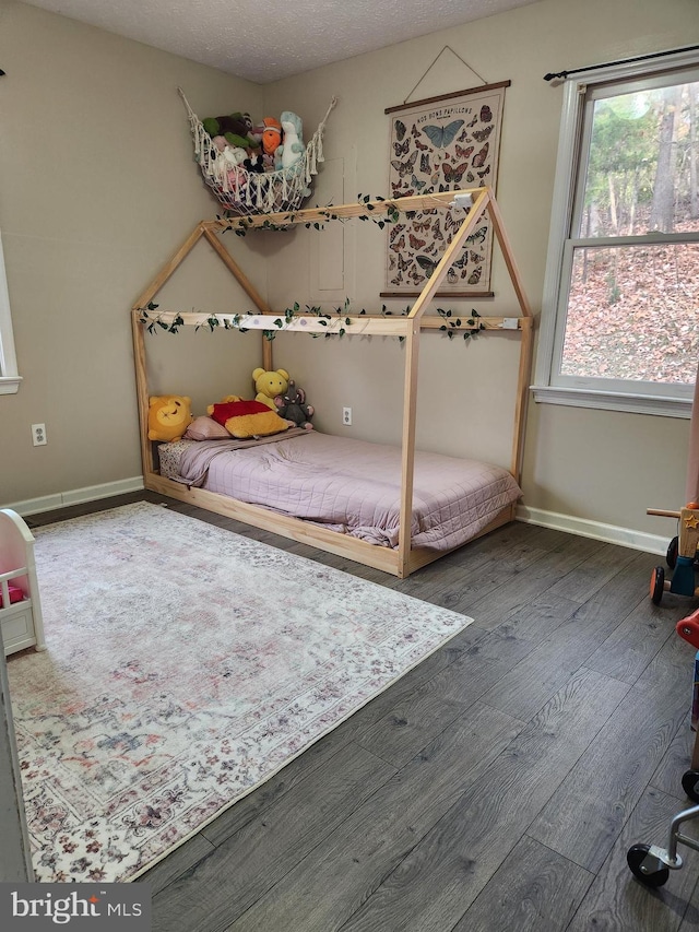 bedroom featuring dark wood-type flooring and a textured ceiling