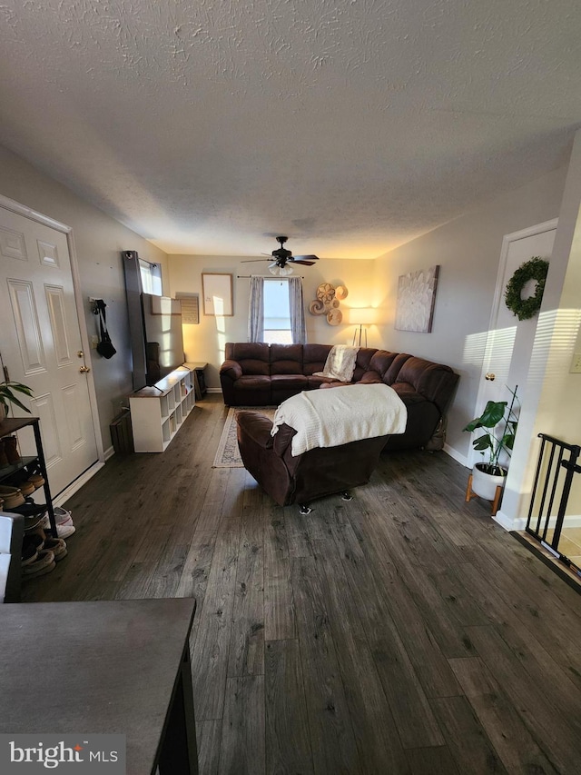 bedroom with ceiling fan, a textured ceiling, and dark hardwood / wood-style flooring