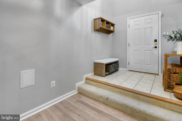 entrance foyer featuring light wood-style floors, baseboards, and stairway