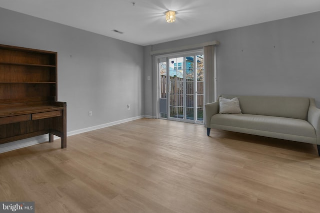 sitting room featuring baseboards, light wood-type flooring, and visible vents