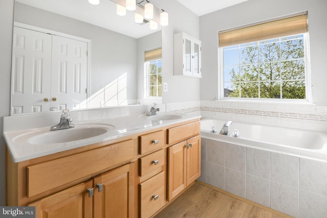 9404 Brigadoon Way, Frederick, MD 21704 - bathroom with double vanity, a sink, a garden tub, and wood finished floors