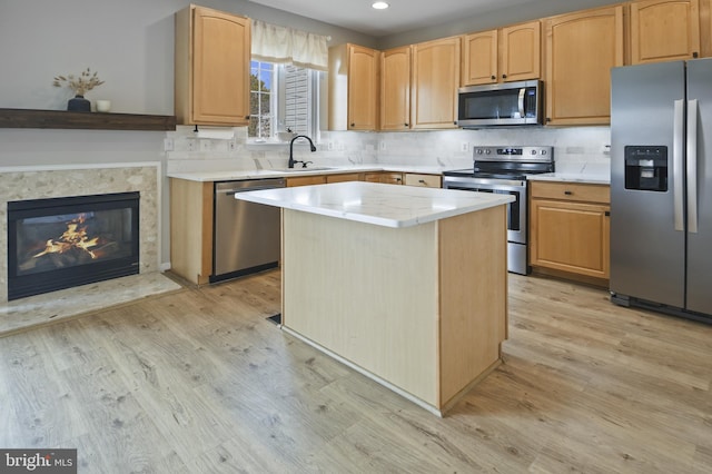 kitchen with light wood-style floors, a center island, recessed lighting, a sink, and stainless steel appliances