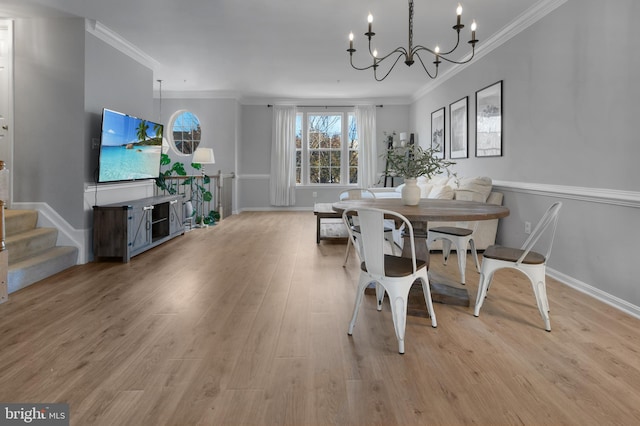 dining area featuring ornamental molding, light wood-style floors, baseboards, stairway, and a notable chandelier