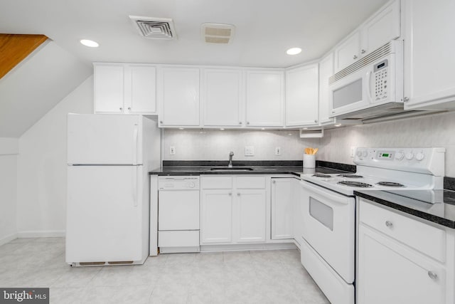 kitchen with tasteful backsplash, white appliances, sink, light tile patterned floors, and white cabinetry