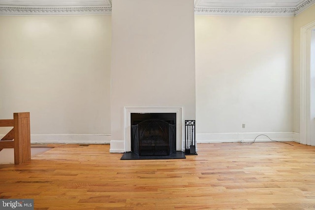 unfurnished living room with light wood-type flooring and crown molding