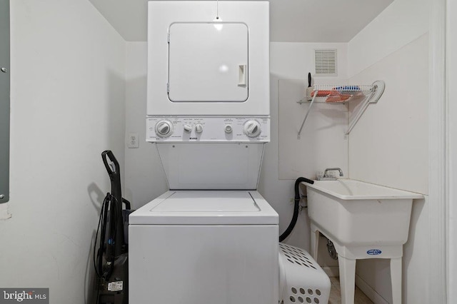 clothes washing area featuring stacked washer and clothes dryer