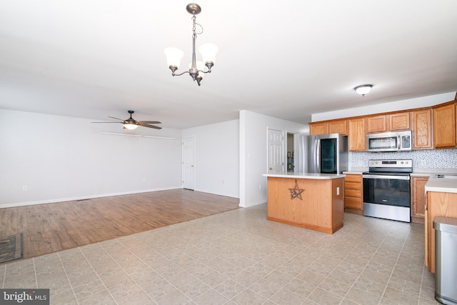 kitchen with a center island, hanging light fixtures, tasteful backsplash, light hardwood / wood-style floors, and appliances with stainless steel finishes