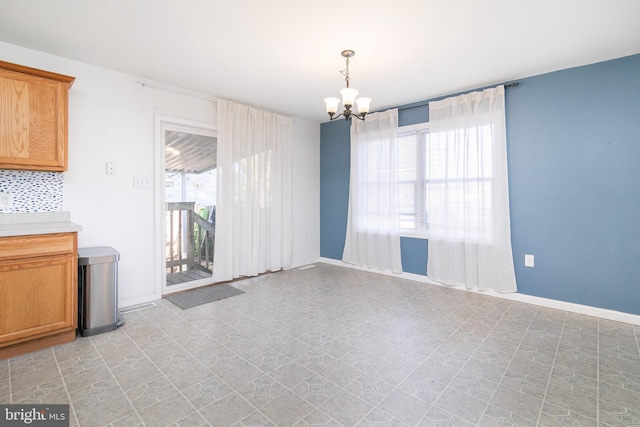 unfurnished dining area with a notable chandelier