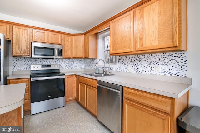 kitchen featuring sink, appliances with stainless steel finishes, and tasteful backsplash