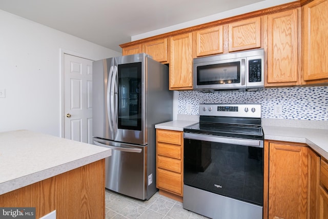 kitchen with tasteful backsplash, light tile patterned flooring, and stainless steel appliances