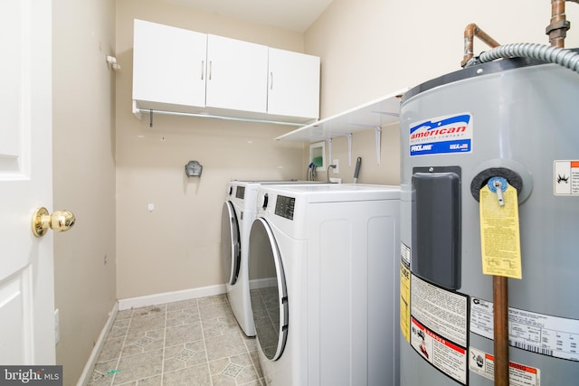 washroom featuring washing machine and clothes dryer, light tile patterned floors, cabinets, and water heater