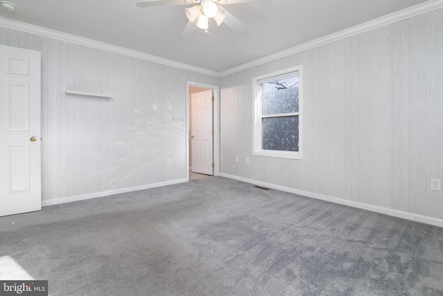 empty room featuring crown molding, carpet floors, and ceiling fan