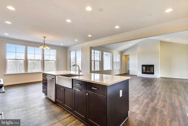 kitchen featuring sink, an island with sink, dark hardwood / wood-style floors, crown molding, and pendant lighting