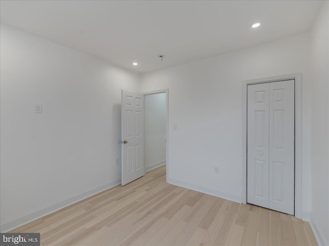 unfurnished bedroom featuring light hardwood / wood-style flooring and a closet