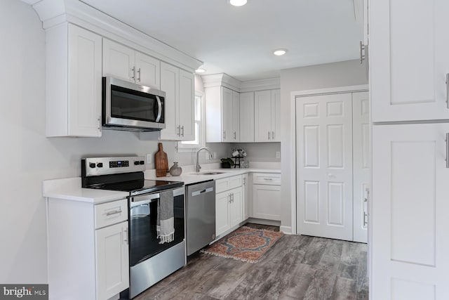 kitchen featuring dark hardwood / wood-style flooring, sink, white cabinetry, and stainless steel appliances