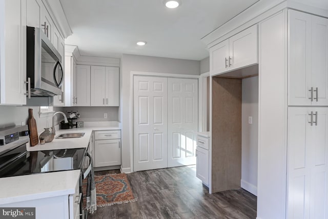 kitchen featuring white cabinets, sink, stainless steel appliances, and dark wood-type flooring