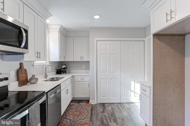 kitchen featuring dark hardwood / wood-style floors, sink, white cabinetry, and stainless steel appliances