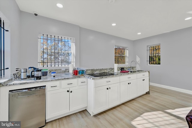 kitchen featuring dishwasher, white cabinets, sink, light stone countertops, and light wood-type flooring