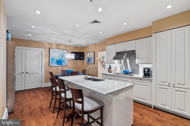 kitchen featuring white cabinetry, sink, a kitchen island with sink, and dark wood-type flooring