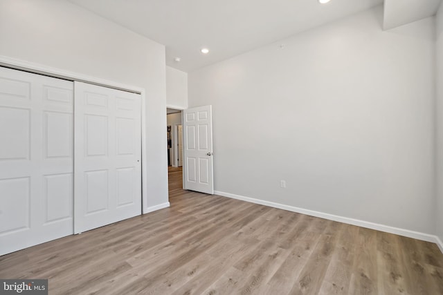 unfurnished bedroom with light hardwood / wood-style floors and a closet