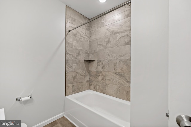 bathroom with tiled shower / bath and hardwood / wood-style floors