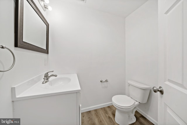 bathroom featuring vanity, hardwood / wood-style flooring, and toilet