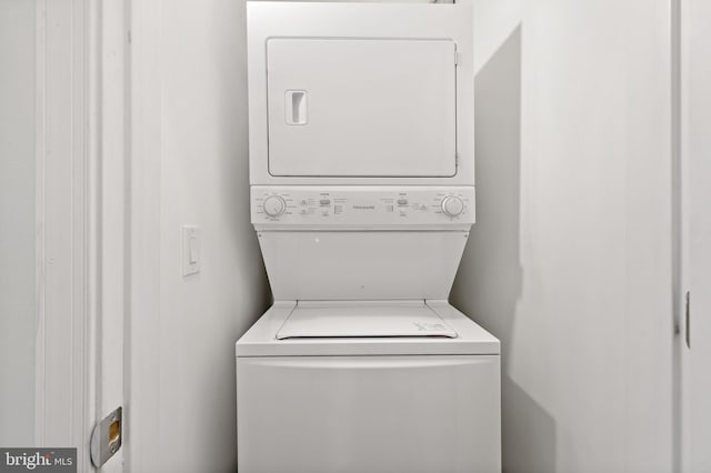 clothes washing area featuring stacked washer / dryer