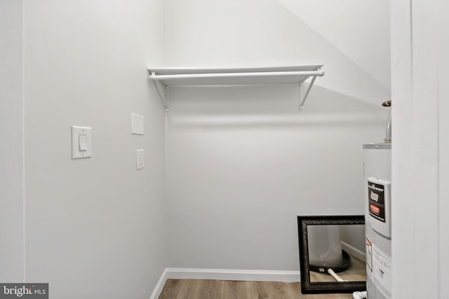 spacious closet featuring hardwood / wood-style flooring and electric water heater