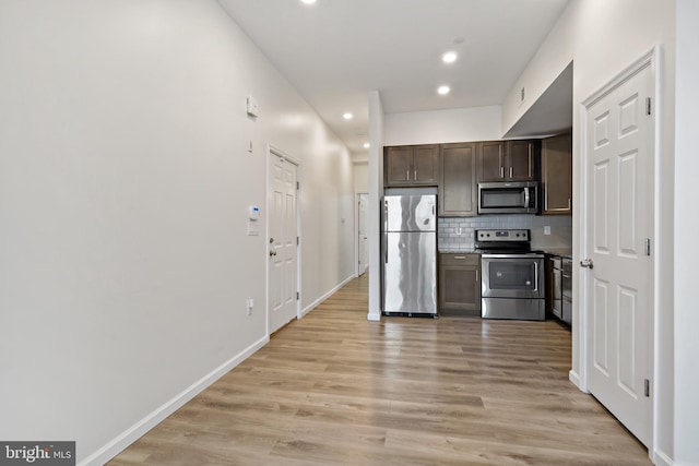 kitchen featuring backsplash, appliances with stainless steel finishes, dark brown cabinets, and light hardwood / wood-style floors