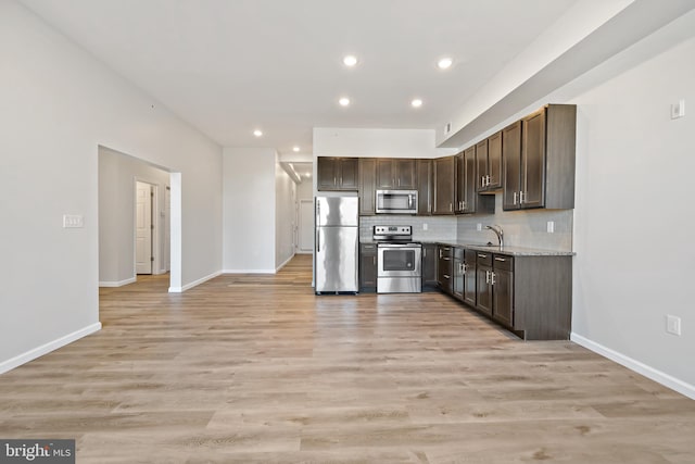 kitchen with light wood-type flooring, appliances with stainless steel finishes, and sink