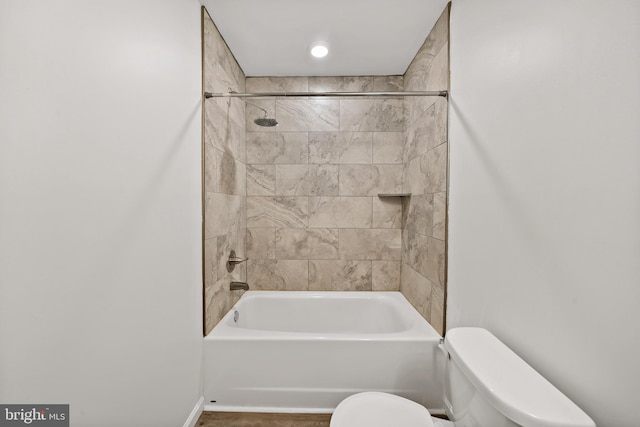 bathroom featuring toilet and tiled shower / bath combo