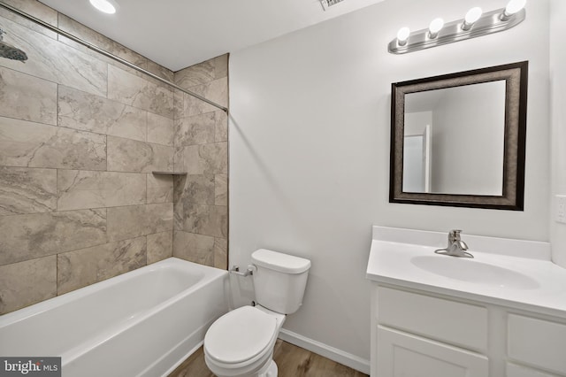 full bathroom with wood-type flooring, tiled shower / bath combo, toilet, and vanity