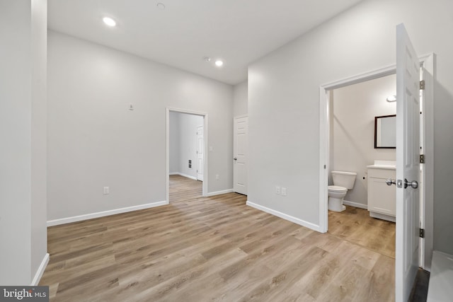 interior space with ensuite bathroom and light hardwood / wood-style flooring