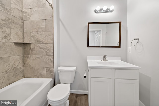 full bathroom featuring hardwood / wood-style floors, vanity, tiled shower / bath combo, and toilet